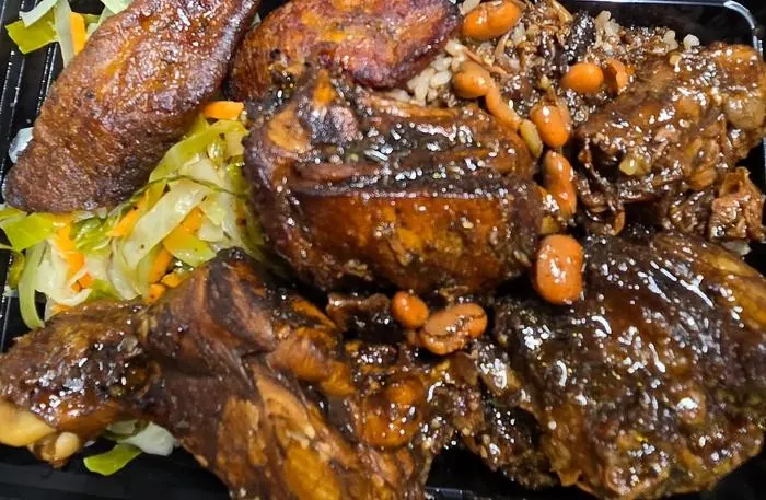Oxtail and chicken combination with rice, beans, vegetables, and plantains